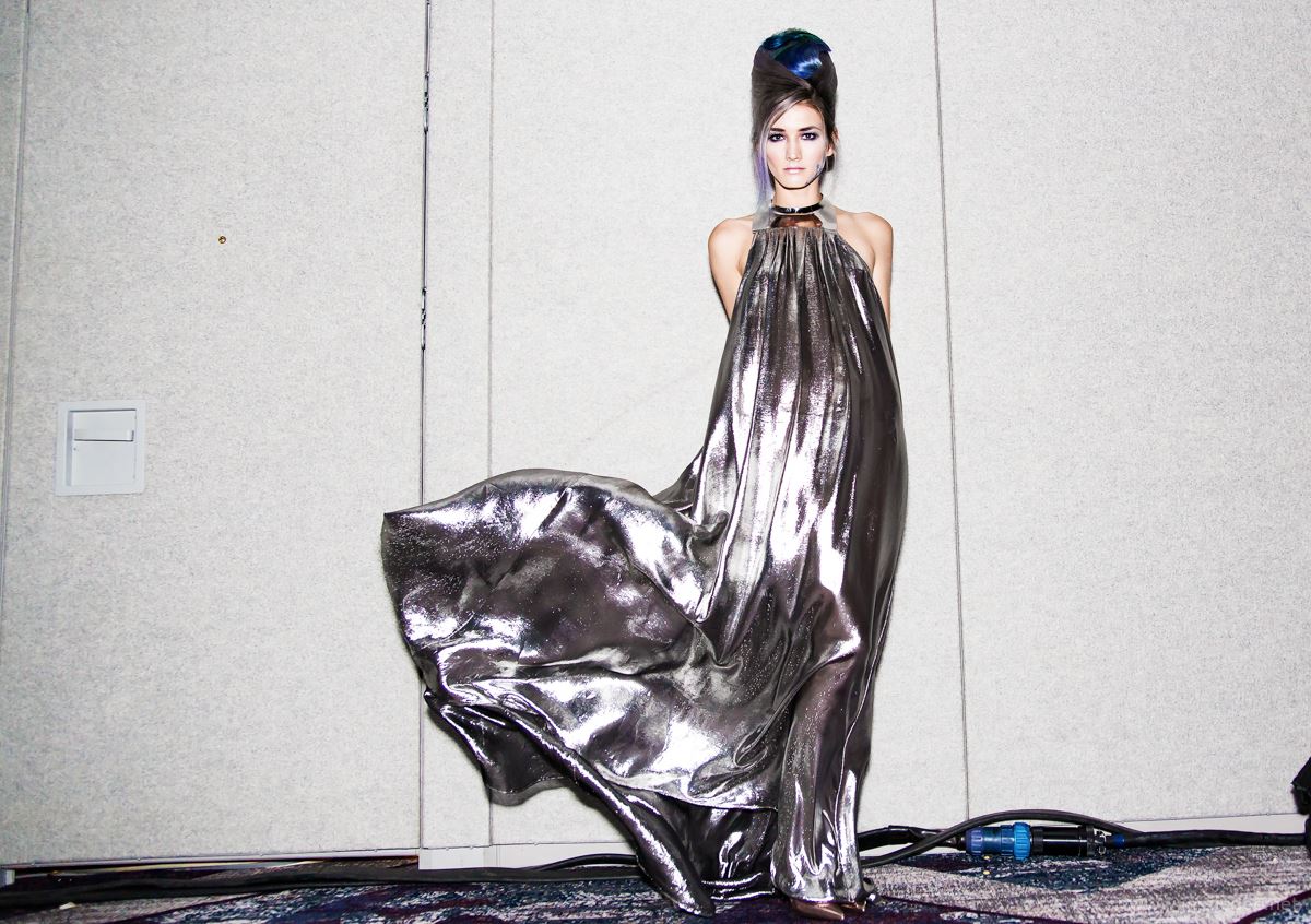 Futuristic blue beehive hair with metallic silver dress backstage at hair show
